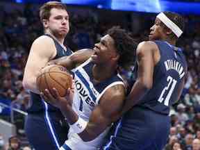 L'attaquant des Minnesota Timberwolves Anthony Edwards tire alors que le gardien des Dallas Mavericks Luka Doncic et le gardien des Dallas Mavericks Frank Ntilikina défendent au cours de la seconde mi-temps au American Airlines Center.