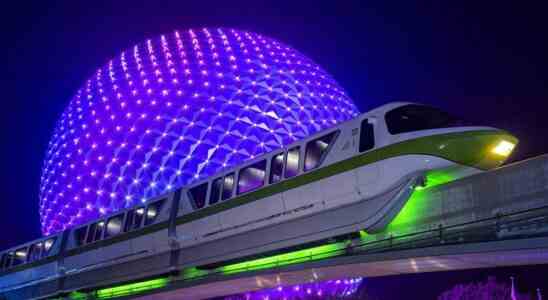 Spaceship Earth lit up at night behind momorail