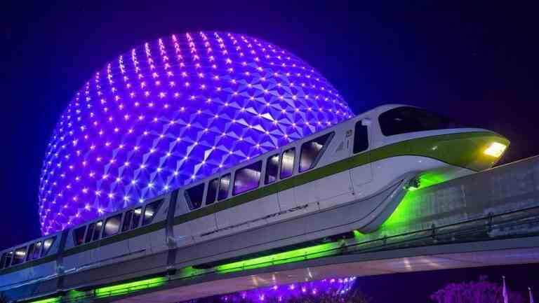 Spaceship Earth lit up at night behind momorail