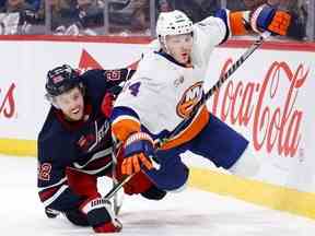 Le centre des Jets de Winnipeg Mason Appleton (22 ans) et le défenseur des Islanders de New York Scott Mayfield (24 ans) s'affrontent en deuxième période au Canada Life Centre à Winnipeg le dimanche 26 février 2023.