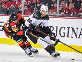 Les Flames de Calgary Tyler Toffoli contre les Coyotes de l'Arizona JJ Moser lors de la troisième période d'action de la LNH au Scotiabank Saddledome le lundi 5 décembre 2022.