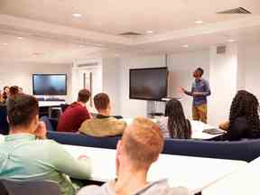 Les étudiants universitaires étudient dans une salle de classe avec un conférencier masculin