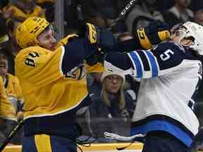 Le défenseur des Jets de Winnipeg Brenden Dillon (5) s'est battu avec l'ailier gauche des Predators de Nashville Tanner Jeannot (84) au cours de la deuxième période à Nashville mardi soir.