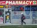 Un piéton passe devant une pharmacie à Parkdale, Toronto. 