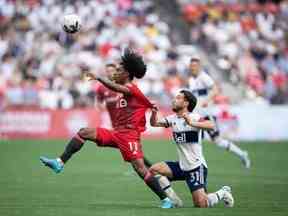 Jayden Nelson du Toronto FC et Russell Teibert des Whitecaps de Vancouver se disputent le ballon lors de la première moitié de la finale du Championnat canadien de soccer, à Vancouver, le mardi 26 juillet 2022.