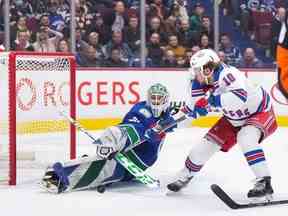 Le gardien de but recrue des Canucks Arturs Silovs s'étale pour arrêter l'ailier des Rangers de New York Artemi Panarin lors d'une échappée lors du match de mercredi – la première apparition de Silovs en saison régulière dans la LNH – au Rogers Arena.