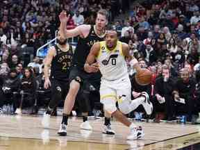 Le garde de l'Utah Jazz Talen Horton-Tucker se dirige vers le panier contre le centre des Raptors de Toronto Jakob Poeltl au cours du quatrième quart à la Scotiabank Arena vendredi soir.