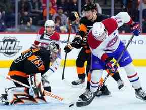 Josh Anderson (17 ans) des Canadiens tente de dévier la rondelle devant Carter Hart (79) et Rasmus Ristolainen (55) des Flyers de Philadelphie, le vendredi 24 février 2023, à Philadelphie.