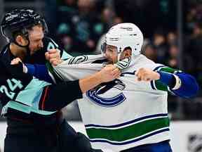 Le défenseur du Seattle Kraken Jamie Oleksiak, à gauche, et le défenseur des Canucks de Vancouver Luke Schenn s'affrontent au Climate Pledge Arena.