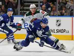 Conor Dewar du Wild du Minnesota tente de contenir Auston Matthews des Maple Leafs de Toronto au Scotiabank Arena le 24 février 2023 à Toronto.