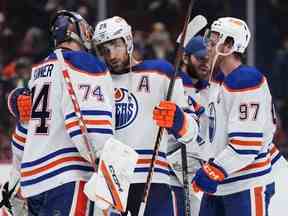 Le gardien des Oilers d'Edmonton Stuart Skinner, à gauche, Leon Draisaitl et Connor McDavid célèbrent après qu'Edmonton ait battu les Canucks de Vancouver 4-2 lors d'un match de la LNH à Vancouver le 21 janvier 2023.