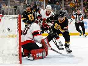 L'ailier gauche des Bruins de Boston Jake DeBrusk (74) marque sur le gardien des Sénateurs d'Ottawa Kevin Mandolese (70) au cours de la première période au TD Garden.