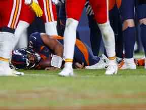 Russell Wilson des Denver Broncos est allongé sur le terrain après avoir subi une commotion cérébrale au quatrième quart d'un match contre les Chiefs de Kansas City à Empower Field At Mile High le 11 décembre 2022.