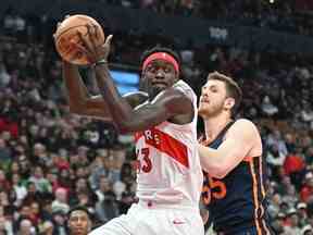 Pascal Siakam des Raptors prend un rebond aux côtés d'Isaiah Hartenstein des New York Knicks lors de la première mi-temps à la Scotiabank Arena le dimanche 22 janvier 2023.