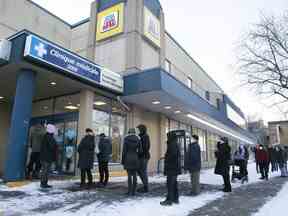 Les gens font la queue pour des tests rapides COVID gratuits devant une pharmacie de Montréal le lundi 20 décembre 2021.