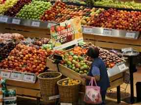 Une femme parcourt la section des fruits d'un supermarché Loblaw Cos. Ltd. à Collingwood, en Ontario.