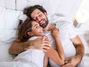 Beau couple d'amoureux s'embrassant au lit.  beau jeune couple allongé ensemble sur le lit.  Romantique jeune couple amoureux allongé sur le lit.  Beau couple souriant au lit.