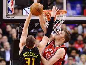 Mike Muscala des Atlanta Hawks voit son tir bloqué par le centre des Raptors Jakob Poeltl lors du match de mardi.  (LA PRESSE CANADIENNE)