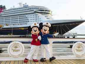 Minnie et Mickey Mouse se tiennent devant le Disney Wish.