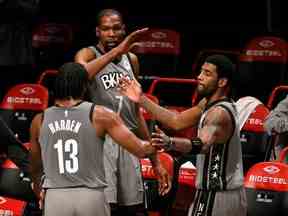 James Harden # 13, Kevin Durant # 7 et Kyrie Irving # 11 des Brooklyn Nets high-five après avoir quitté le terrain en seconde période contre le Miami Heat au Barclays Center le 25 janvier 2021 à Brooklyn.