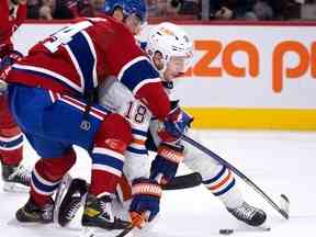 Le défenseur des Canadiens de Montréal Jordan Harris entraîne l'ailier gauche des Oilers d'Edmonton Zach Hyman lors de la deuxième période à Montréal le 12 février 2023.