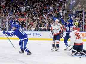 Mitch Marner (à gauche) et Michael Bunting des Maple Leafs célèbrent un but de leur coéquipier Morgan Rielly, non illustré, sous le regard du gardien des Capitals de Washington Darcy Kuemper pendant la deuxième période à Toronto le dimanche 29 janvier 2023.