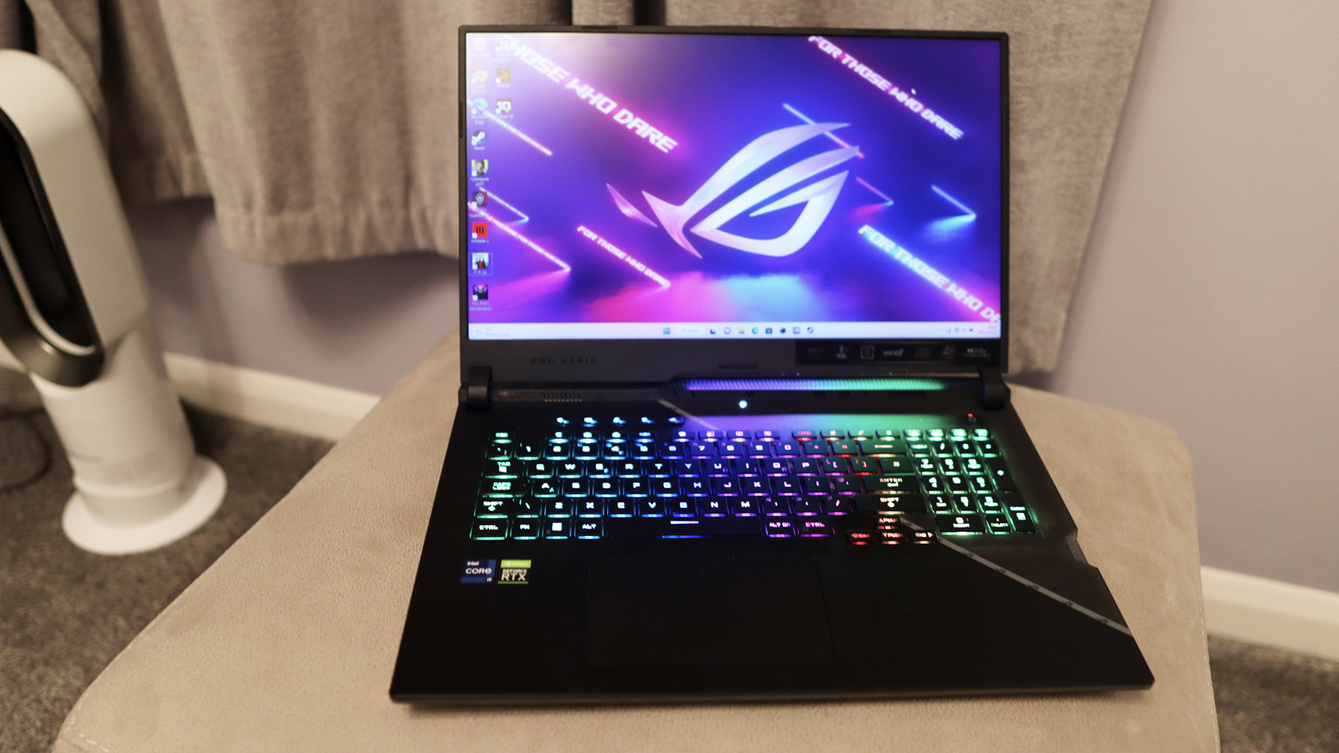 Test de l'Asus ROG Strix Scar 17 : un ordinateur portable de jeu placé sur un support beige, son clavier RVB brillant