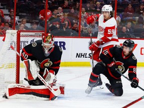 Le gardien de but des Sénateurs d'Ottawa Mads Sogaard effectue un arrêt alors que le défenseur Jake Sanderson contrôle l'ailier gauche des Red Wings de Détroit Tyler Bertuzzi au cours de la deuxième période au Centre Canadian Tire, le mardi 28 février 2023.