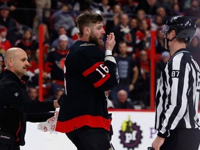 L'ailier gauche des Sénateurs d'Ottawa Austin Watson montre à un officiel son visage ensanglanté qu'il a reçu d'un bâton haut alors qu'il marquait contre les Red Wings de Detroit lors de la première période au Centre Canadian Tire le mardi 28 février 2023.