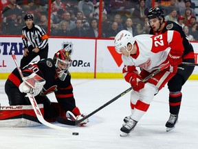 Le gardien de but des Sénateurs d'Ottawa Mads Sogaard effectue un arrêt contre l'ailier gauche des Red Wings de Détroit Lucas Raymond alors que l'ailier droit Drake Batherson défend au cours de la deuxième période au Centre Canadian Tire le mardi 28 février 2023.