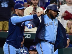 Le joueur de premier but des Blue Jays de Toronto, Vladimir Guerrero Jr., reçoit la veste bleue du lanceur Jose Berrios après avoir frappé un home run en solo contre les Cardinals de St. Louis lors de la sixième manche au Busch Stadium.  (Jeff Curry - USA TODAY Sports)