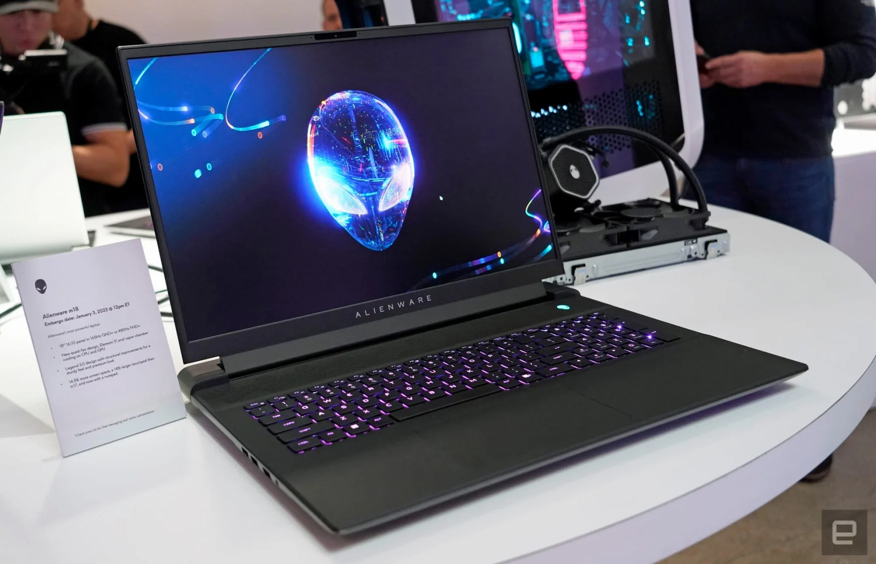 Photo du showroom CES de l'ordinateur portable Alienware m18.  L'ordinateur portable de couleur sombre est posé sur une table blanche avec un logo extraterrestre sur son écran.