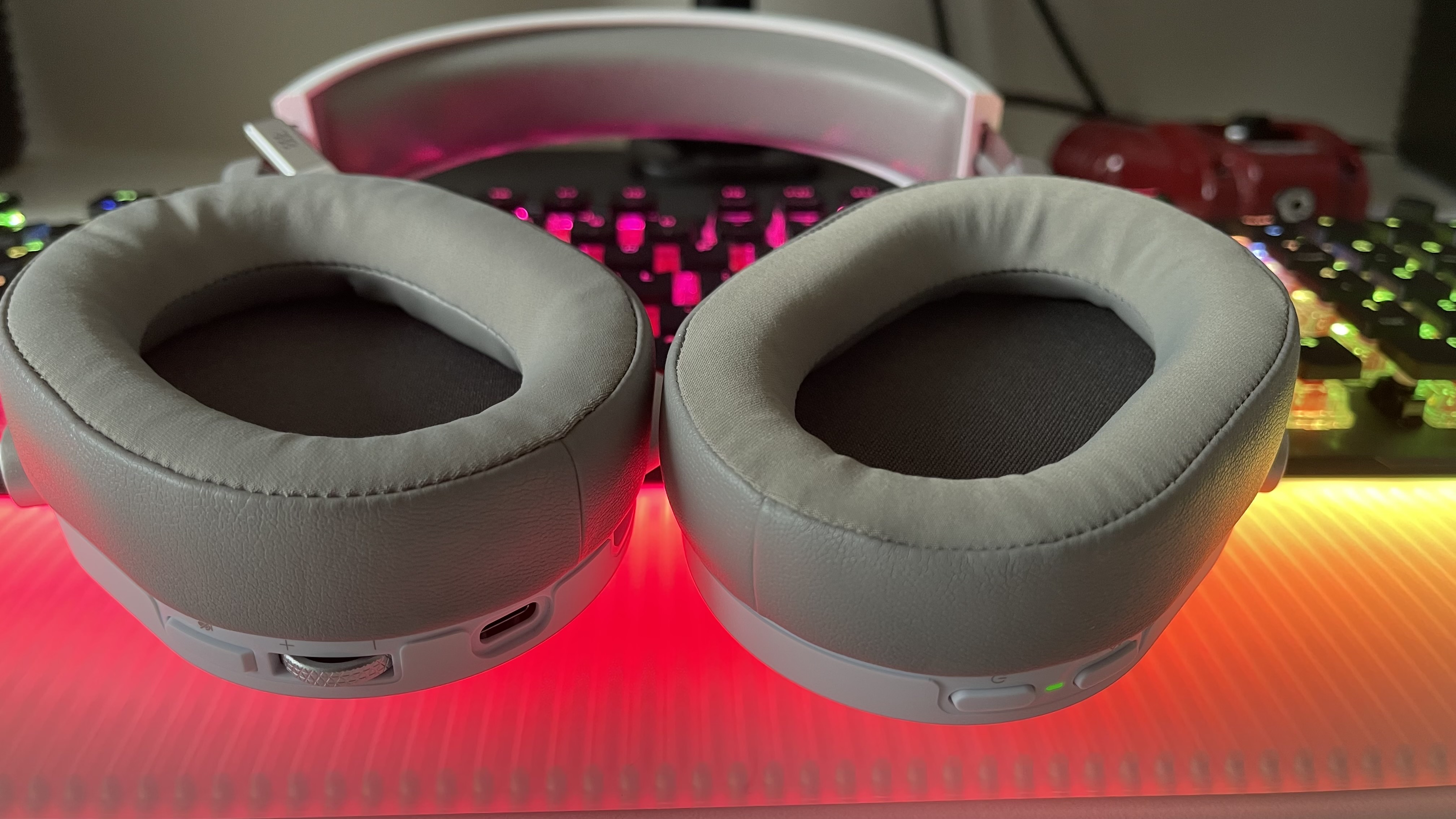 Casque de jeu sans fil Corsair HS65 ouvert pour montrer l'intérieur des tasses sur un bureau avec un clavier en arrière-plan