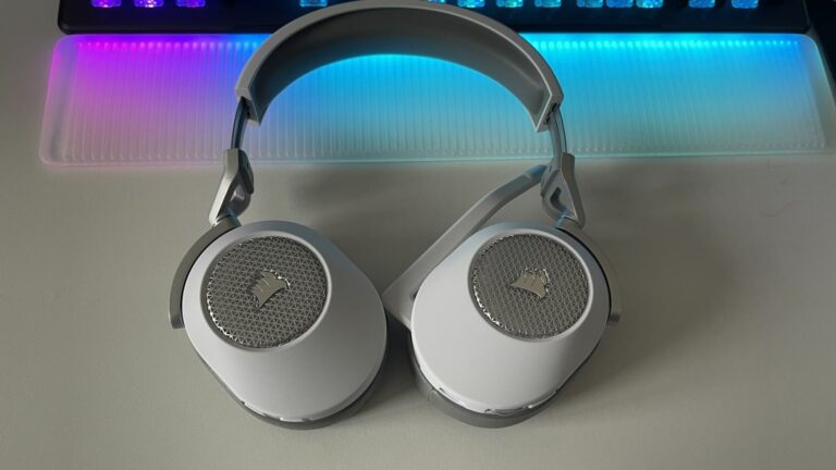 Corsair HS65 Wireless gaming headset sitting on a desk with RGB lighting