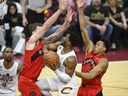 Le garde des Cleveland Cavaliers Donovan Mitchell (45 ans) se dirige vers le panier entre le centre des Raptors de Toronto Jakob Poeltl (19 ans) et l'attaquant Scottie Barnes.