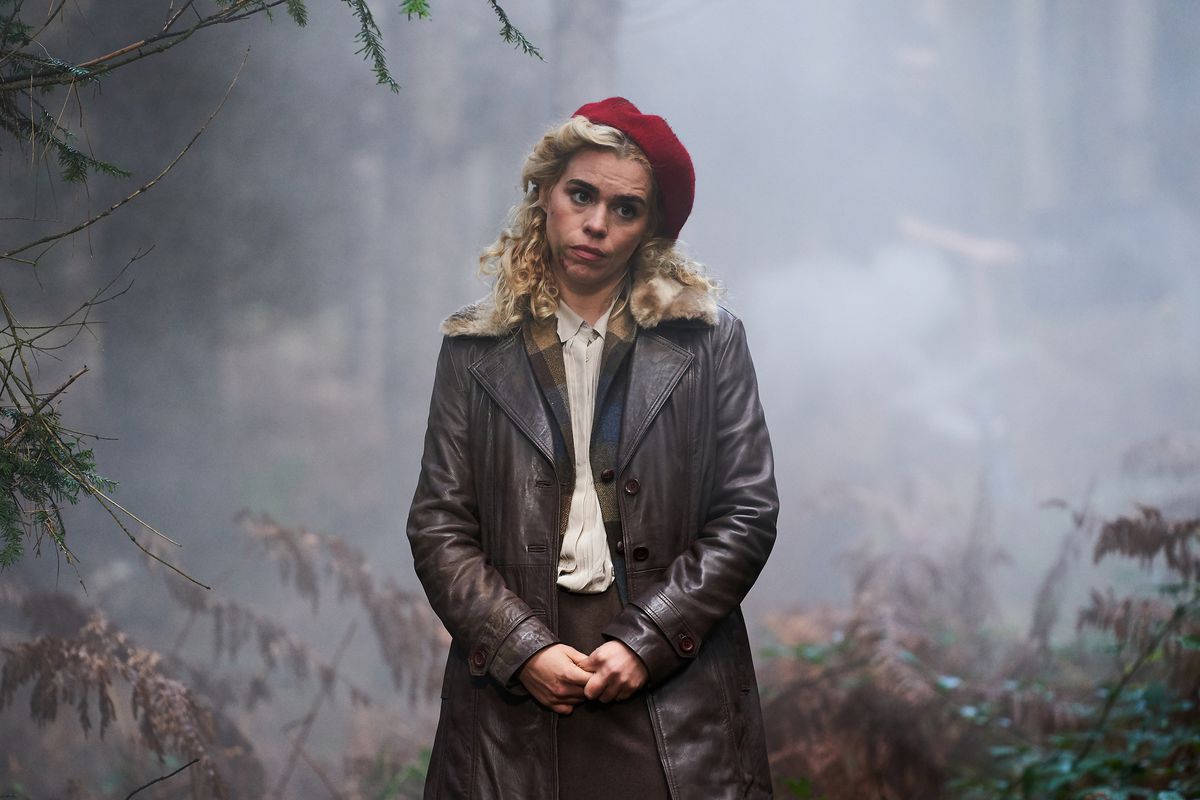 Billie Piper incline la tête tout en portant un béret rouge et un manteau noir dans une sorte de zone boisée dans I Hate Suzie.