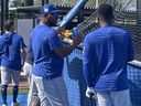 Edwin Encarnacion (au milieu) parle de la boutique autour de la cage des frappeurs lors de l'entraînement de printemps à Dunedin, en Floride.