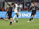 25 février 2023 ;  Washington, District de Columbia, États-Unis ;  Le défenseur du Toronto FC Richie Laryea dribble le ballon alors que le défenseur du DC United Pedro Santos poursuit en première mi-temps à Audi Field. 