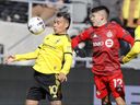 Le milieu de terrain de Columbus Crew Lucas Zelarayán, à gauche, protège le ballon alors que le défenseur du Toronto FC Kadin Chung défend pendant la seconde moitié d'un match de football MLS le samedi 12 mars 2022 à Columbus, Ohio.  