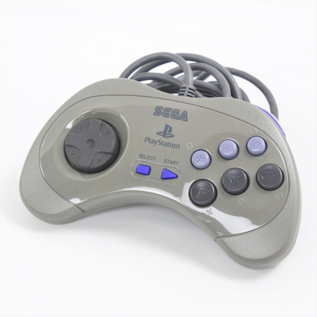 Une manette grise de marque Sega Playstation avec 8 boutons directionnels sur la gauche, des boutons de démarrage et de sélection bles au milieu et une disposition à six boutons sur la droite - X, Y, Z boutons en bleu clair le long du haut et A, B, C. boutons en dessous gris foncé.