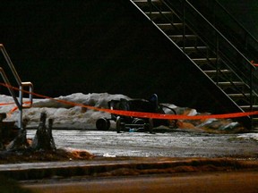 Une poussette repose sur le côté derrière un ruban de police sur le site d'un accident mortel à Amqui, au Québec, le lundi 13 mars 2023. Une femme a été blessée, mais son enfant était en sécurité.