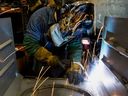 Un travailleur utilise un soudeur mig dans une usine de fabrication de poêles à charbon à Berwick, en Pennsylvanie. 