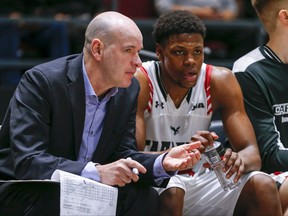 L'ancien entraîneur-chef Dave Smart discute avec Alain Louis sur le banc alors que les Ravens de Carleton affrontent les Dinos de Calgary lors des quarts de finale des Championnats U SPORTS Final 8 2020 à la Place TD à Ottawa.