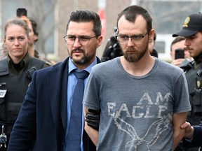 Steeve Gagnon est escorté par la police hors du tribunal à Amqui, au Québec, le mardi 14 mars 2023. Gagnon fait face à des accusations liées à un incident au cours duquel le conducteur d'une camionnette a percuté des piétons, tuant deux personnes et en blessant neuf.