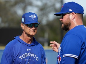 L'entraîneur de banc des Blue Jays Don Mattingly, à gauche, s'entretient avec le manager John Schneider lors de l'entraînement printanier de baseball à Dunedin, en Floride, le mardi 21 février 2023.