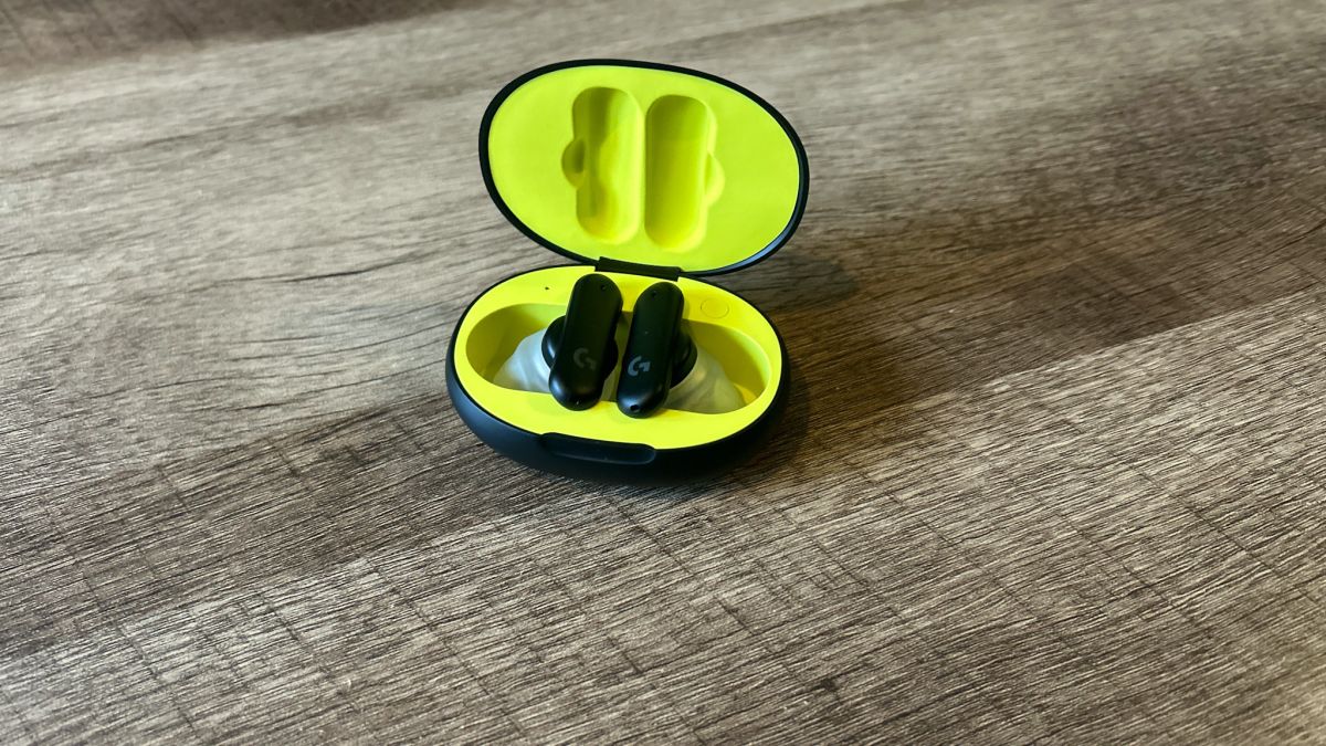 Logitech G Fits earbuds in a black and yellow case on a wooden table