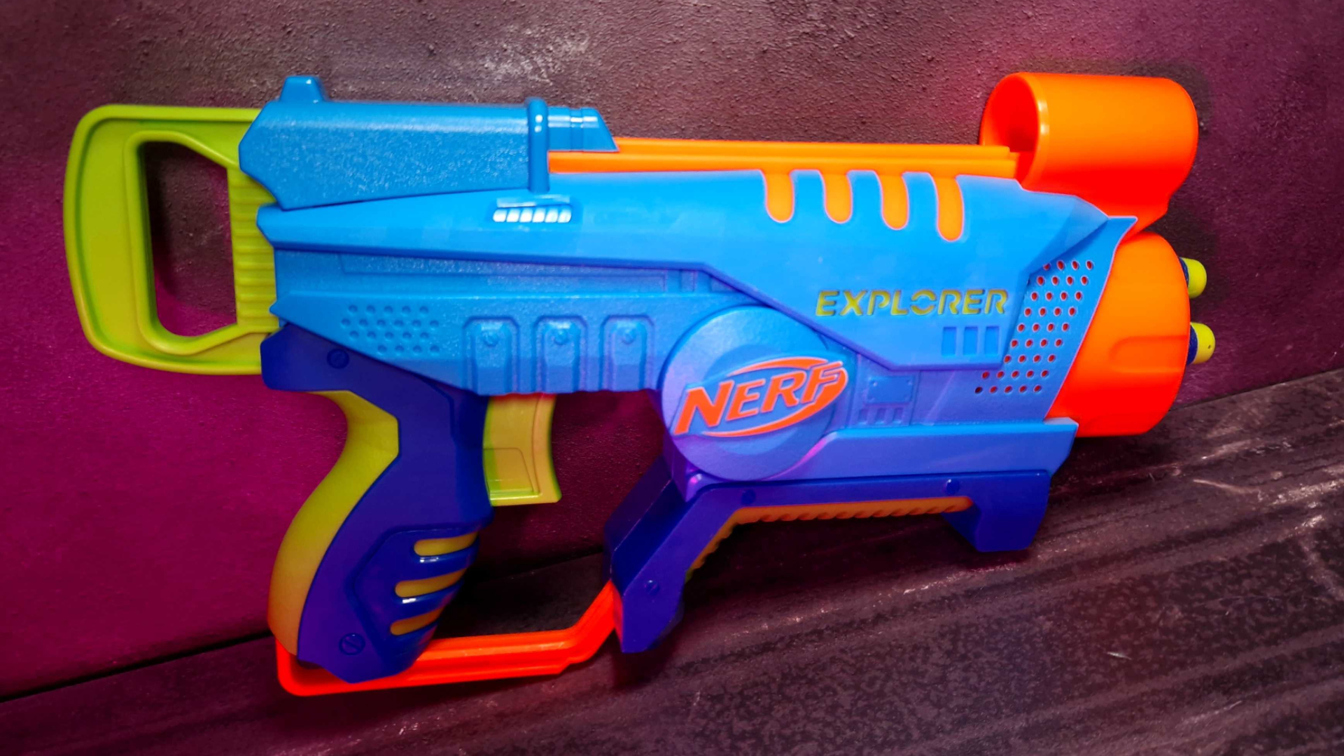 Un blaster Nerf Elite Jr. Explorer, appuyé sur un fond sombre