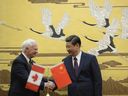 L'ancien gouverneur général David Johnston (à gauche) serre la main du président chinois Xi Jinping (à droite) après une cérémonie de signature au Grand Palais du Peuple à Pékin le 18 octobre 2013. Photo de KOTA ENDOKOTA ENDO/AFP/Getty Images