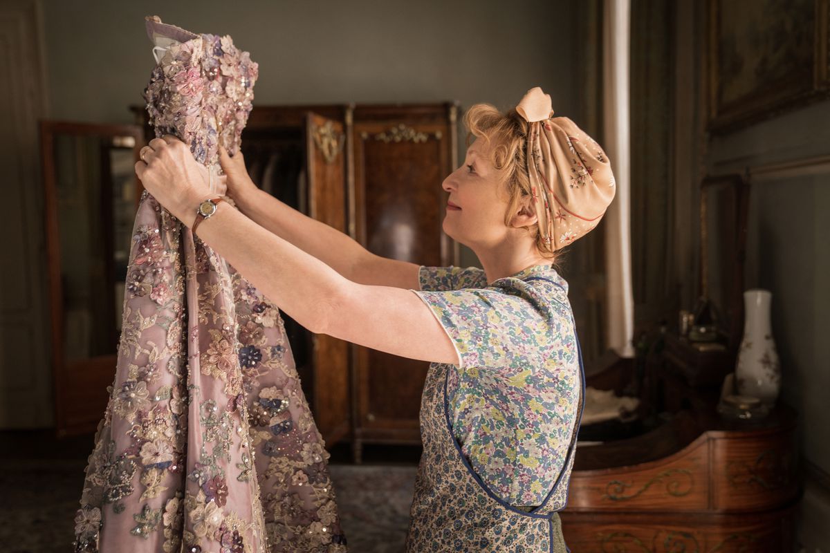 Lesley Manville regarde une robe dans Mme Harris va à Paris.