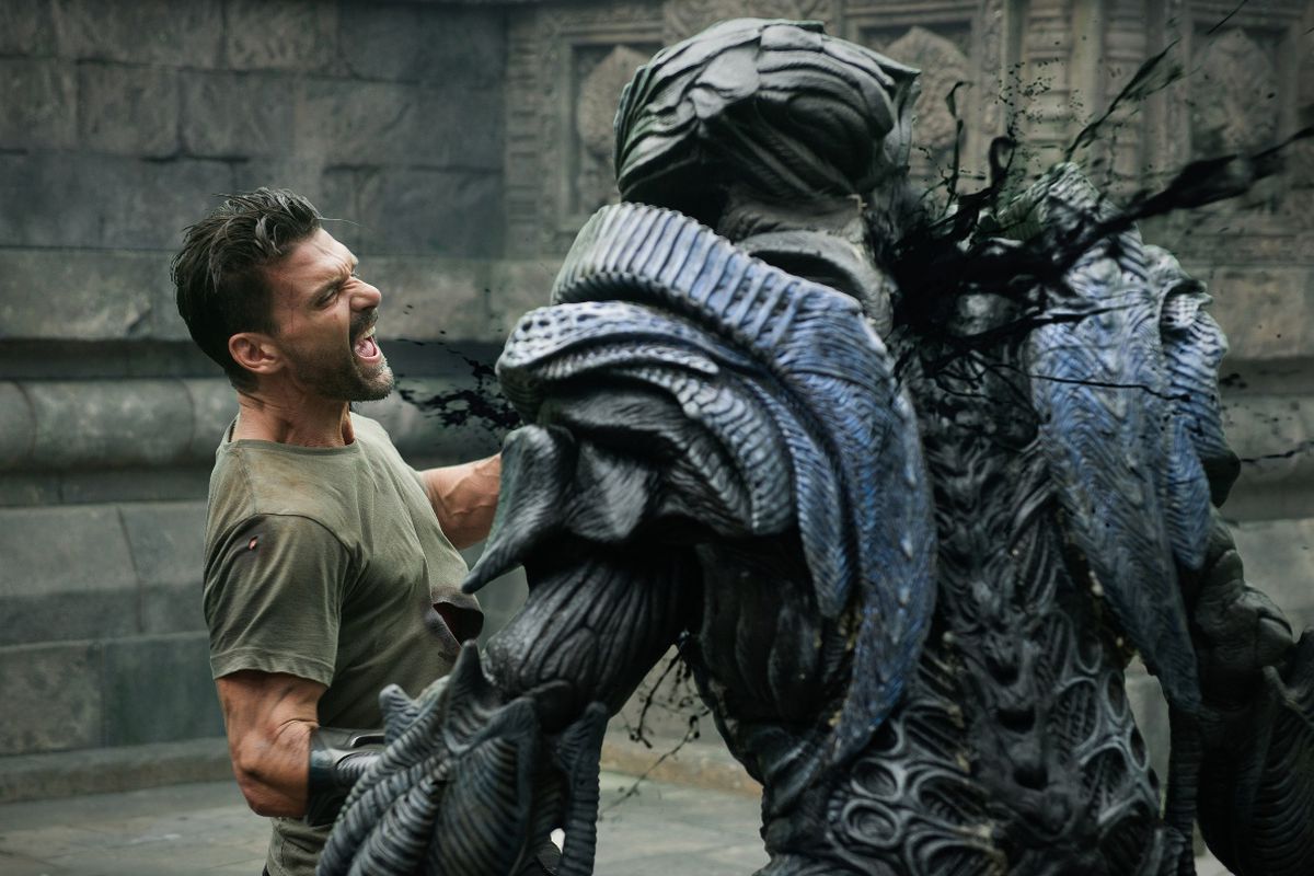 Frank Grillo dans le rôle de Mark Corley dans Beyond Skyline, tuant un grand extraterrestre humanoïde.  Le corps de l'extraterrestre est fait de plaques d'armure organique qui se chevauchent.